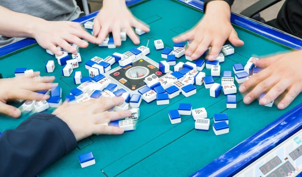 People shuffling mahjong tiles